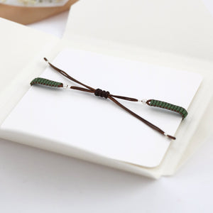 Green Morse code bracelet on a card package